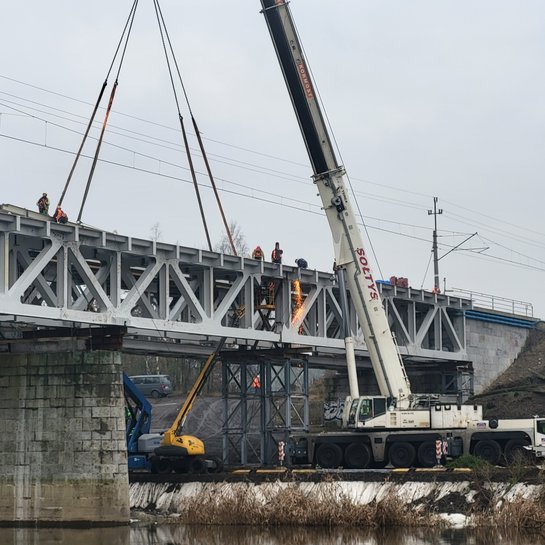 Dźwig przy budowie nowego przęsła mostu nad Wartą w Obornikach, widoczna rzeka, ceglane przęsło, a na góze sieć trakcyjna_fot.Radek Śledziński