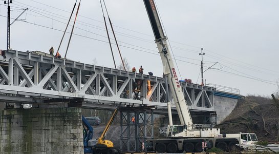 Dźwig przy budowie nowego przęsła mostu nad Wartą w Obornikach, widoczna rzeka, ceglane przęsło, a na góze sieć trakcyjna_fot.Radek Śledziński