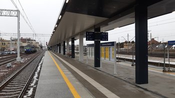 Nowy peron na stacji Czechowice-Dziedzice, wiata i tablica z nazwą stacji, po torze przejeżdża pociąg, fot. Damian Żaba
