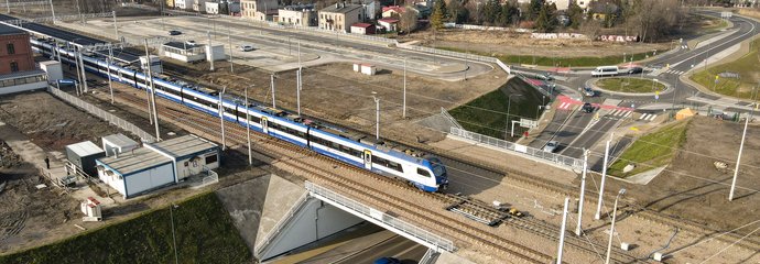 Dąbrowa Górnicza, po wiadukcie kolejowym jedzie pociąg, pod obiektem samochody, widok z lotu ptaka, fot. Grzegorz Biega