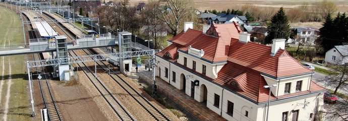 Widok z góry na stację Modlin, widać tory, kładkę dla pieszych oraz budynek dworca, fot. P. Mieszkowski