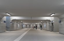 Rzeszów Główny szare wnętrze oświetlonego nowego tunelu podziemnego. W tle podróżni. fot. Szymon Grochowski