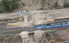 Widok z góry na tory kolejowe i przejeżdżający pociąg na CMK na szlaku Opoczno Płd. - Pilichowice km 101,970.1