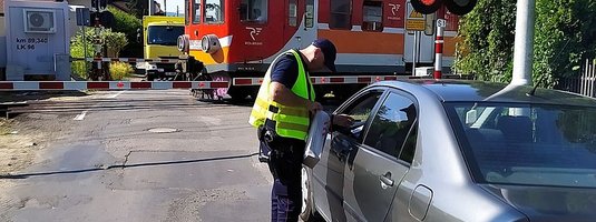 Pociąg na zamkniętym przejeździe, Sokista wręcza ulotkę kierowcy w samochodzie
