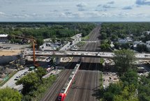 Widok z góry na budowę wiaduktu nad torami na ul. Chełmżyńskiej w Warszawie, pod wiaduktem jedzie pociąg, fot. A.Lewandowski, P.Mieszkowski