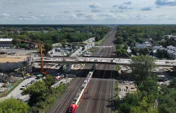 Budowa wiaduktu na ul. Chełmżyńskiej w Warszawie Widok z góry na budowę wiaduktu nad torami na ul. Chełmżyńskiej w Warszawie, pod wiaduktem jedzie pociąg, fot. A.Lewandowski, P.Mieszkowski