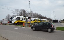 Do przejazdu na ul. Przy Torze we Wrocławiu zbliża się pociąg Kolei Dolnośląskich. Przed opuszczonymi rogatkami przed przejazdem stoi samochód osobowy. Fot2. M. Pabiańska