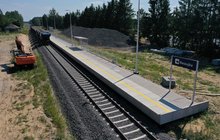 Widok z poziomu ziemi na modernizowany przystanek kolejowy Raszujka. W kadrze widać pociąg towarowy, fot. Szymon Grochowski