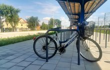 Rower przypięty do stojaka na parkingu przy stacji kolejowej w Kościanie