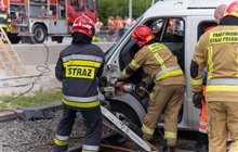 Strażacy pracujący przy warku samochodu podczas symulacji wypadku.