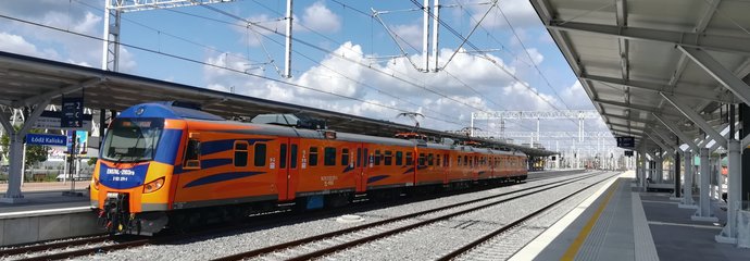 Pomarańczowy pociąg wjeżdzający na perony stacji Łódź Kaliska. Autor Rafał Wilgusiak