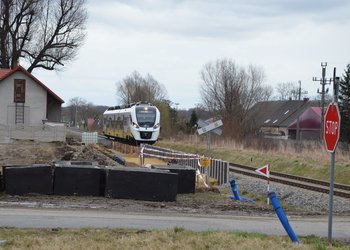 Budowa przystanku w Strzelcach. Widać pracującą koparkę oraz lnadjeżdżający pociąg i znak STOP przed przejazdem. Fot 2. M. Pabiańska