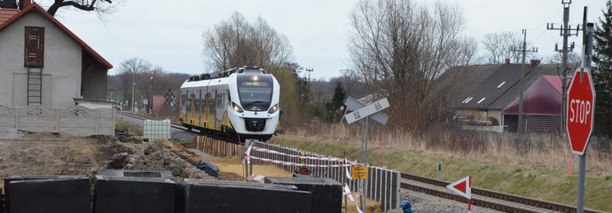 Budowa przystanku w Strzelcach. Widać pracującą koparkę oraz lnadjeżdżający pociąg i znak STOP przed przejazdem. Fot 2. M. Pabiańska