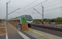 Pociąg pasażerski jadący po torach kolejowych, budowa przystanku Warszawa Targówek fot. Martyn Janduła