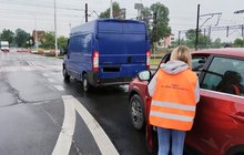 Przedstawicielka PLK SA rozmawia z kierowcą samochodu przed przejazdem kolejowo-drogowym; fot. Przemysław Zieliński