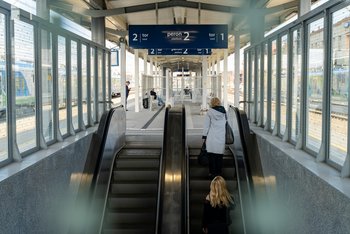 Podróżne wjeżdżają na nowy peron stacji Rzeszów Gł. schodami ruchomymi. Nad nimi tablice informacyjne. fot. Szymon-Grochowski