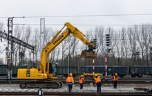 Przystanek Zduńska Wola Karsznice, układanie torów, koparka, robotnicy, w tle pociąg Fot. Łukasz Bryłowski PLK