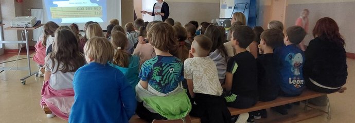 Przedstawicielka PLK SA przedstawia dzieciom w szkole podstawowej prezentację o bezpieczeństwie na terenach kolejowych; źródło PKP Polskie Linie Kolejowe S.A. (1)