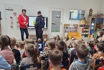 Spotkanie edukacyjne w szkole, sala z prelegentami i młodzieżą.