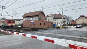 Przejazd kolejowo-drogowy w Lublińcu, samochody oczekują przed zamkniętymi rogatkami, na przejeździe pociąg, fot. Katarzyna Głowacka