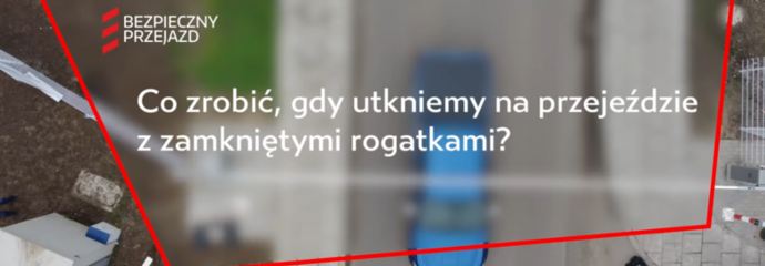Ujęcie z filmu, widok kamery z góry na samochód, tekst Co zrobić gdy utkniemy na przejeździe.