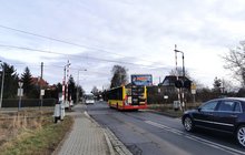 Przejazd kolejowy na ul. Krzemienieckiej we Wroclawiu. Widać autobus miejski przejeżdżający przez tory, za nim czarny samochód. Z naprzeciwka nadjeżdża biały autokar. Fot. M. Pabiańska.