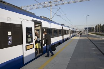 Pasażerowie wsiadający do pociągu na peronie w Nidzicy