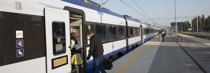 Pasażerowie wsiadający do pociągu na peronie w Nidzicy