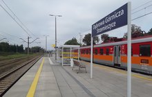 Stacja Dąbrowa Górnicza Strzemieszyce, na peronie wiata i ławka, tablica z nazwą stacji i pociąg regionalny, fot. Mateusz Kozłowski
