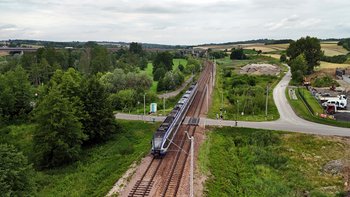 Przejazd kolejowo-drogowy w Szczepanowicach Pociąg przejeżdża przez przejazd kolejowo-drogowy w Szczepanowicach, w miejscu gdzie powstaną nowe perony, widok z lotu ptaka, fot. Piotr Hamarnik