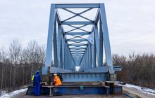 Widok z poziomu ziemi na nasuwanie mostu kolejowego na rzece Narew. Widać konstrukcje przęsła. 19.01.2022 r., fot. Łukasz Bryłowski, źródło PLK, zdjęcie nr 2