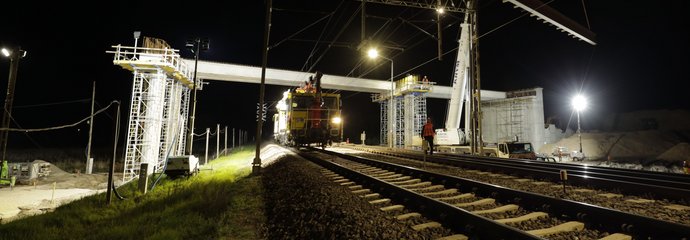 Budowa wiaduktu w Małkini, dźwig układa zbrojone belki, jedzie drezyna, autor Łukasz Bryłowski