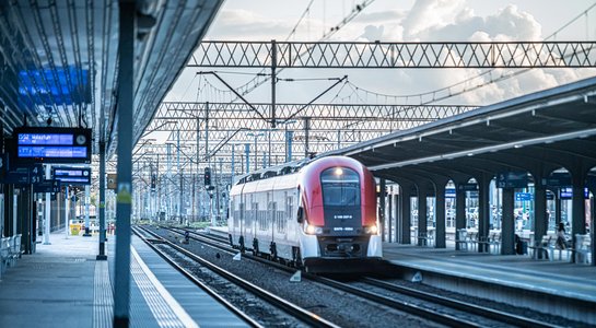 Pociąg przy peronie na stacji Poznań Główny, na pierwszym planie tory, powyżej sieć trakcyjna_fot.Rafał Meszka