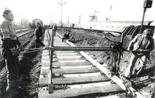 Stare, czarno-białe zdjęcie robotników układających w 1986 tor na stacji Olsztyn_fot. Michał Puzewicz