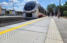 Nawierzchnia nowego peronu w Grodzisku Wielkopolskim, w oddali pociąg i podróżni_fot.Radek Śledziński