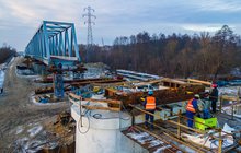 Widok z poziomu ziemi na nasuwanie mostu kolejowego na rzece Narew. Widać konstrukcje przęsła. 19.01.2022 r., fot. Łukasz Bryłowski, źródło PLK, zdjęcie nr 1
