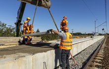 Siedlce Łaskie, budowa nowego peronu, pracownicy układają płyty, Ł. Bryłowski PKP Polskie Linie Kolejowe S.A.