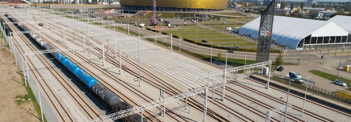 Widok z góry na tory i pociąg, w tle stadion. Stacja Amber Expo Gdańsk,09.09.2021. fot. Paweł Nowakowski