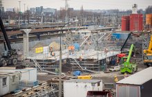 Widok na plac budowy na stacji Warszawa Zachodnia, pracownicy wykorzystują maszyny, w tle perony, fot. PLK