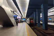 Pasażerowie na peronie stacji Warszawa Centralna, widać wjeżdzający pociag, fot. Martyn Janduła