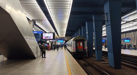 Pasażerowie na peronie stacji Warszawa Centralna, widać wjeżdzający pociag, fot. Martyn Janduła