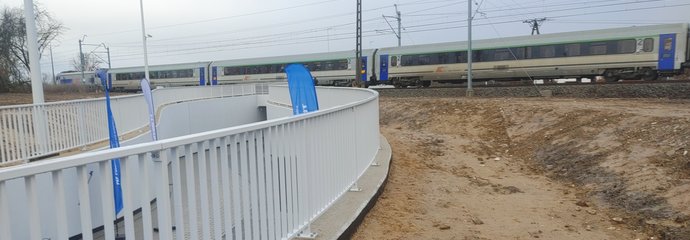 Pociąg przejeżdżający nad nowym przejściem w Kiekrzu, z przodu barierki tunelu_fot.Radek Śledzińsk
