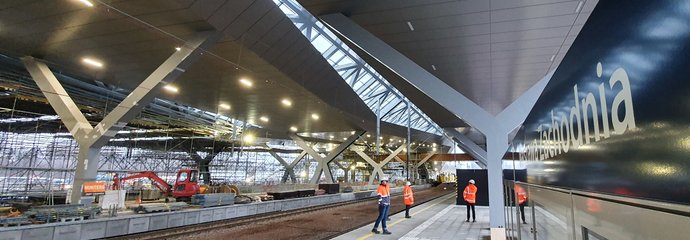 Widok na budowę nowych peronów na stacji Warszawa Zachodnia, na peronie trzech pracowników w odblaskowej odzieży ochronnej