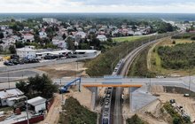 Widok z góry na pociąg jadący po torze pod nowym wiadukrem drogowym w Warce, fot. Artur Lewandowski