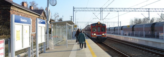 Stacja Sławków, podróżni czekają na nadjeżdżający pociąg, widać wiatę i tablicę informacyjną, fot. Katarzyna Głowacka