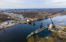 Widok z lotu ptaka na nasuwanie mostu kolejowego na rzece Narew na linii Ostrołęka-Chorzele. W oddali widać las i miasto. 19.01.2022. Fot. Łukasz Bryłowski, PLK