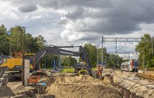 Budowa wiaduktu_Andrespol_koparka buduje ściany w tle pociąg na torach _Łukasz Bryłowski