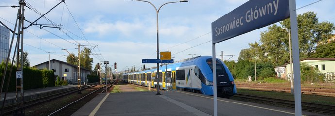 Stacja Sosnowiec Główny, widoczny pociąg, na peronie tablica z nazwą stacji, fot. Katarzyna Głowacka