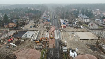 Widok z góry na budowę tunelu kolejowo-drogowego w Sulejówku, widać maszyny, wykonawców i przejeżdzający pociąg, fot. P. Mieszkowski, A. Lewandowski (1)
