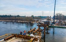 Nasuwanie mostu kolejowego na rzece Narew. W oddali widać rozłożone ramie dźwigu. 19.01.2022 r., fot. Łukasz Bryłowski, PLK